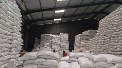 Sejumlah pekerja mengemas beras di gudang beras milik Bulog, Kabupaten Garut, Jawa Barat.