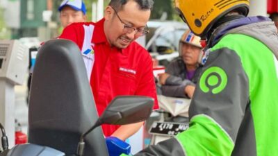 Direktur Utama PT Pertamina Patra Niaga Mars Ega Legowo Putra (kiri) mengisikan BBM ke pelanggan.