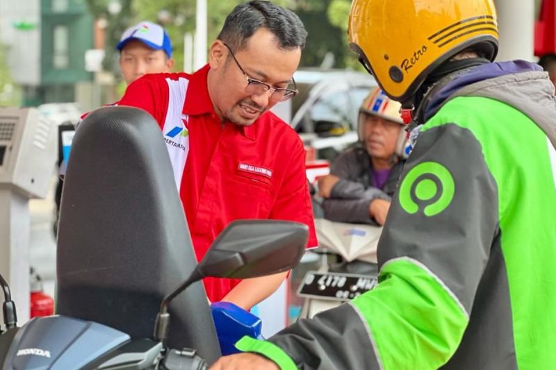 Direktur Utama PT Pertamina Patra Niaga Mars Ega Legowo Putra (kiri) mengisikan BBM ke pelanggan.