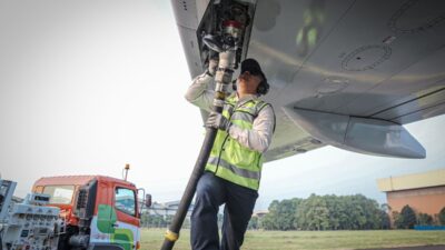 Seorang Pekerja sedang mengisi bahan bakar Avtur kedalam pesawat.