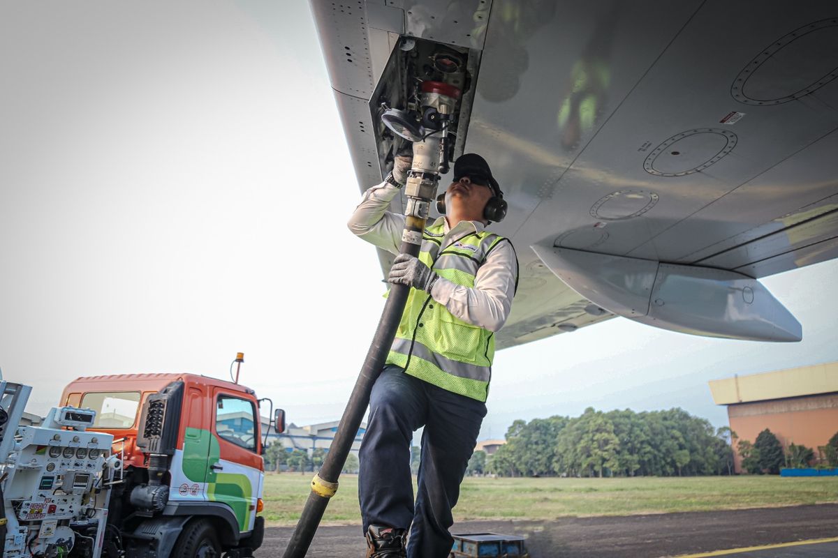 Seorang Pekerja sedang mengisi bahan bakar Avtur kedalam pesawat.