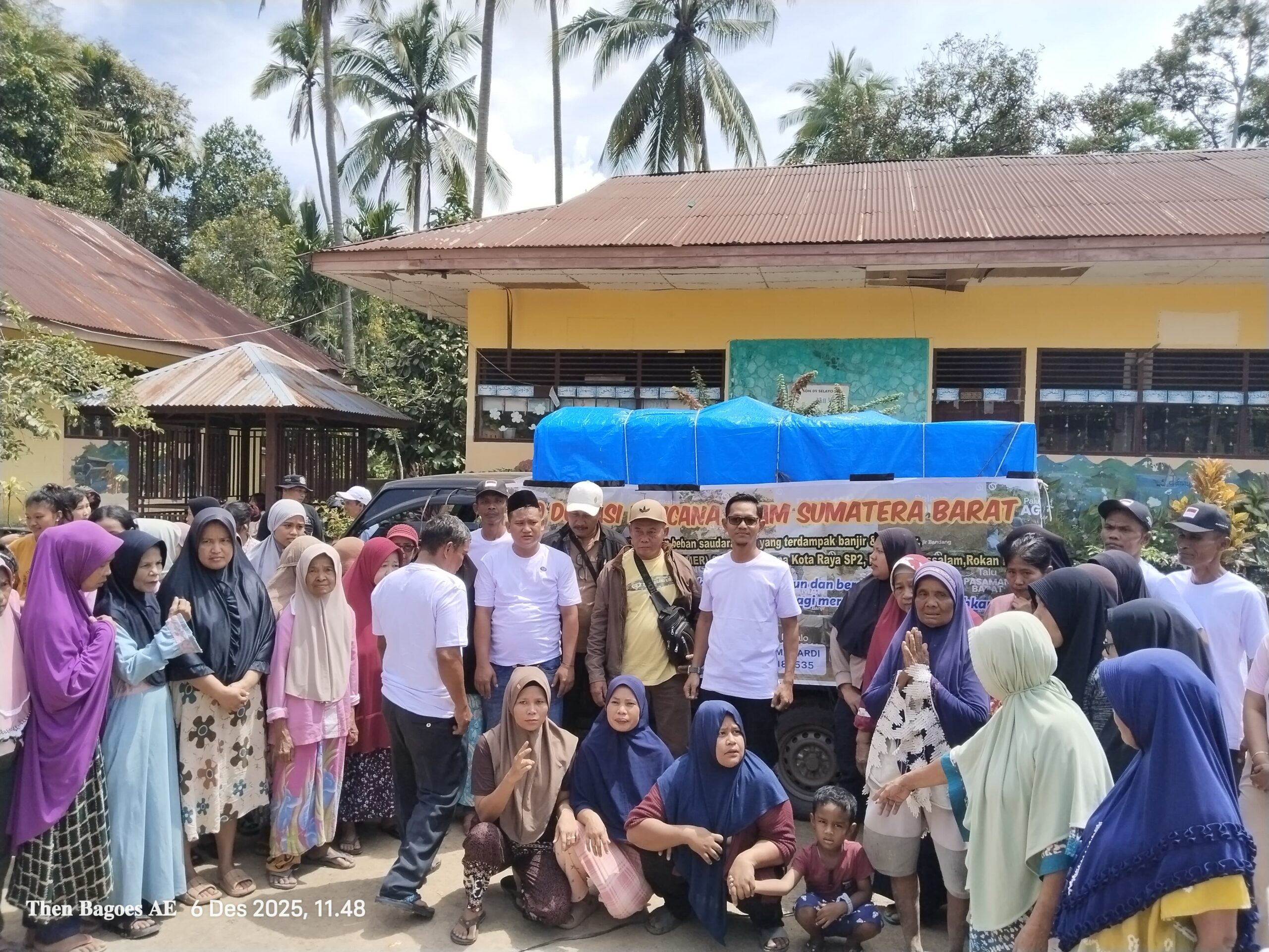Tim Relawan Desa Muara Jaya, Kota Raya dan IKMER saat menyerahkan bantuan kepada masyarakat korban bencana alam Sumatera Barat (6/12/25).